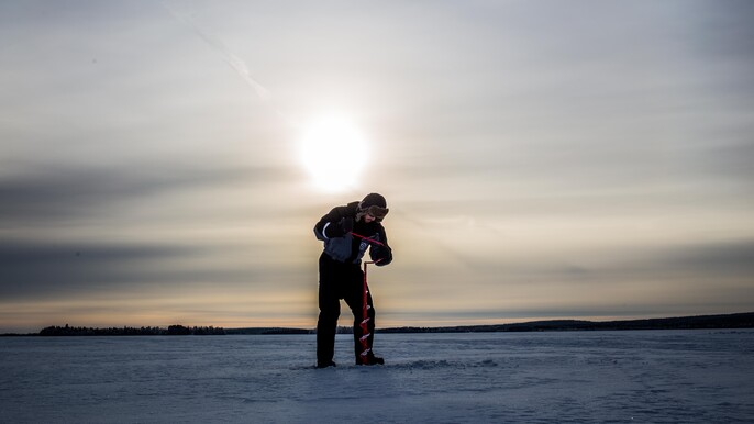 Ice Fishing on frozen lake in Levi